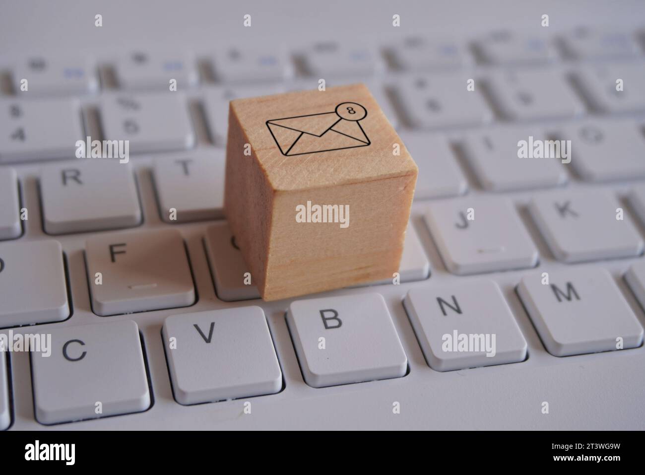 Cubo di legno con nuova icona di notifica e-mail sulla tastiera. Concetto di comunicazione e tecnologia Foto Stock