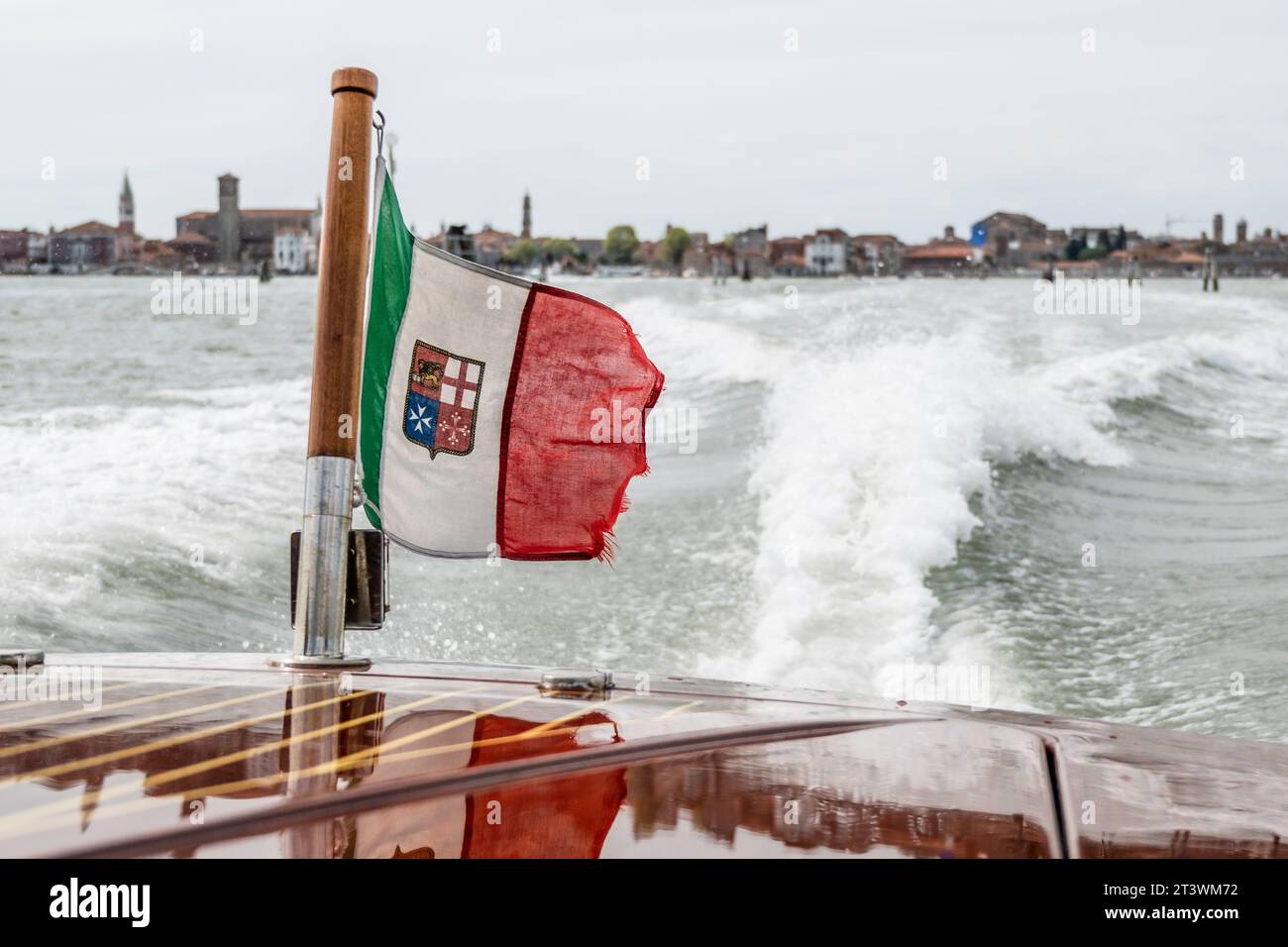 La bandiera veneziana, che sventola dal retro di un taxi d'acqua, sulla laguna veneziana Foto Stock