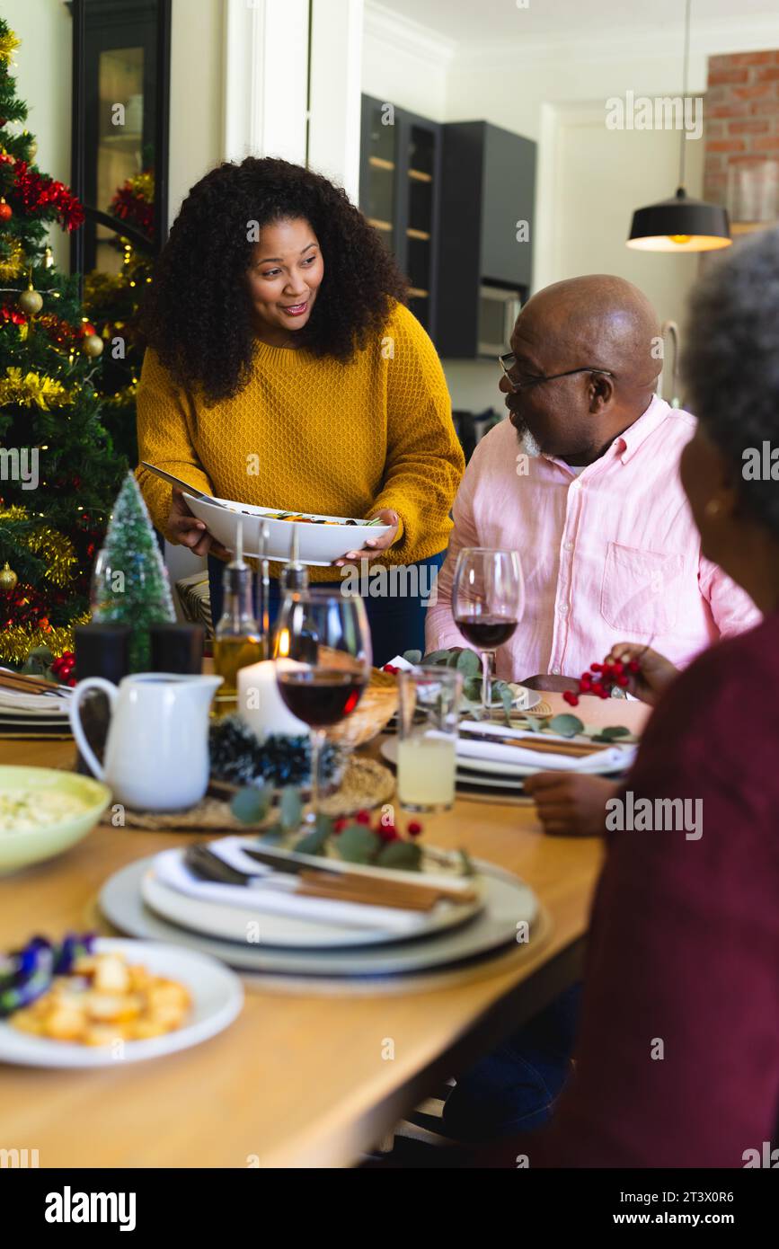 Felice famiglia afro-americana che cena di natale nella sala da pranzo decorata a casa Foto Stock