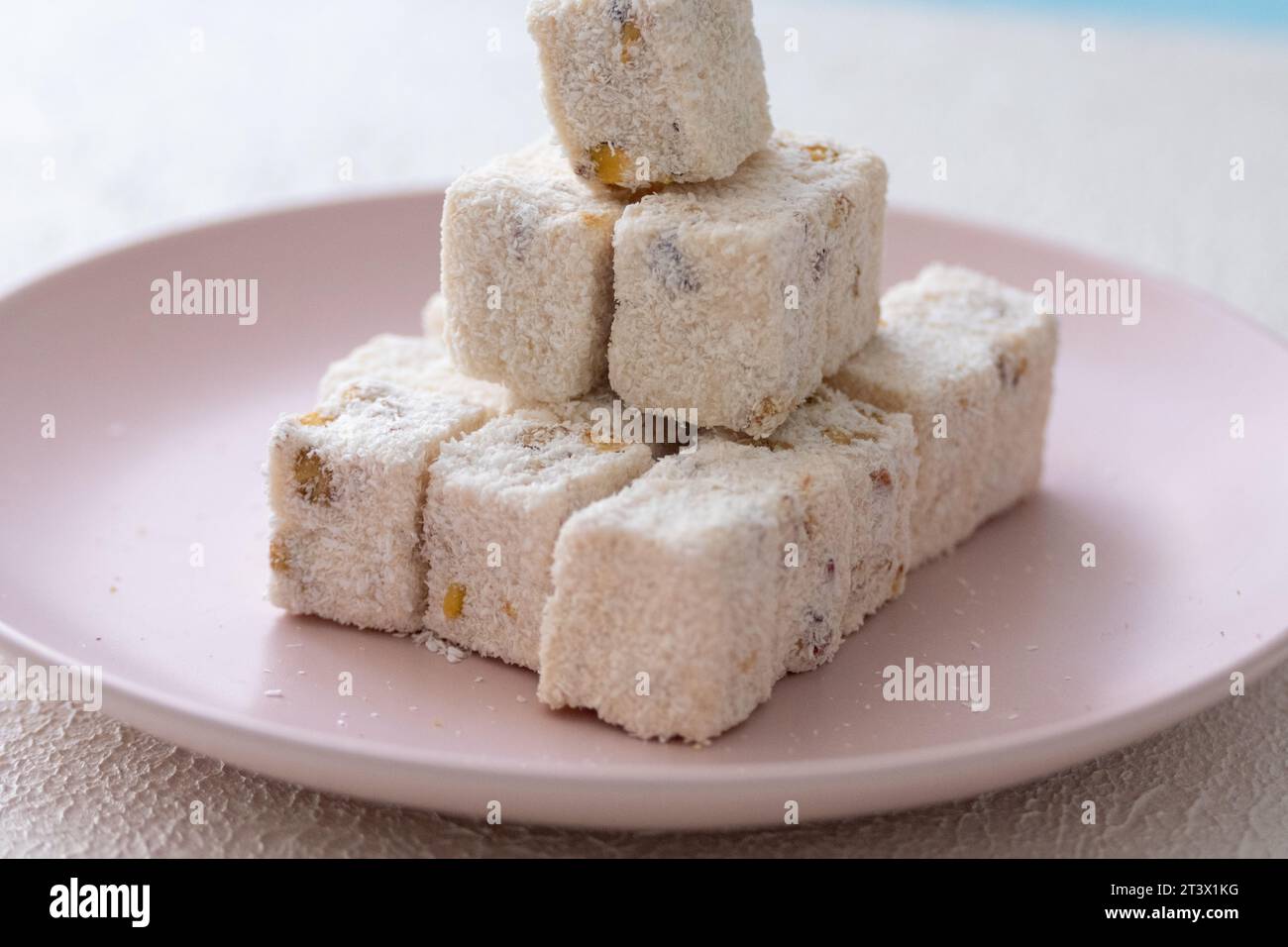 Delizie turche con nocciole, pistacchi, noci, cocco e rose su un piatto rosa Foto Stock