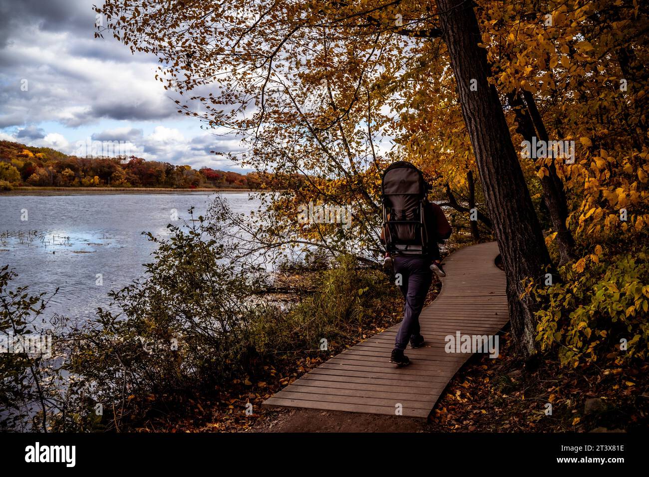 Escursione di padre e figlio a Wood Bridge presso il lago in un giorno buio Foto Stock