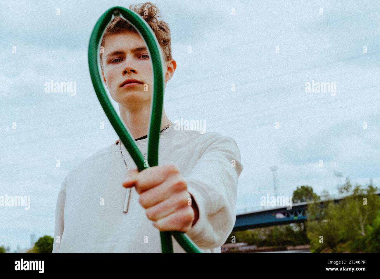 Ritratto di un uomo sicuro che tiene il tubo da giardino contro il cielo Foto Stock