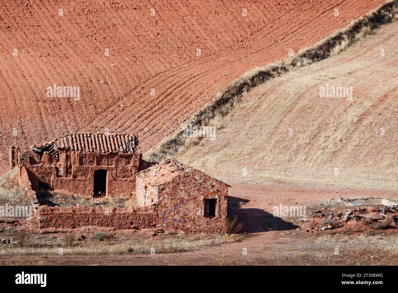 Casa in rovina tra campi piastrellati e stoppia Foto Stock