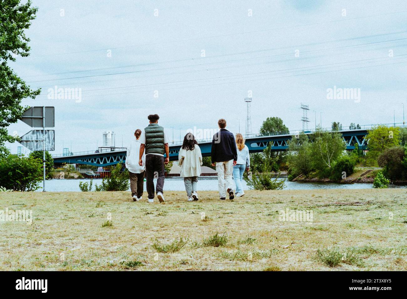 Vista posteriore completa dei giovani amici che camminano verso il fiume Foto Stock