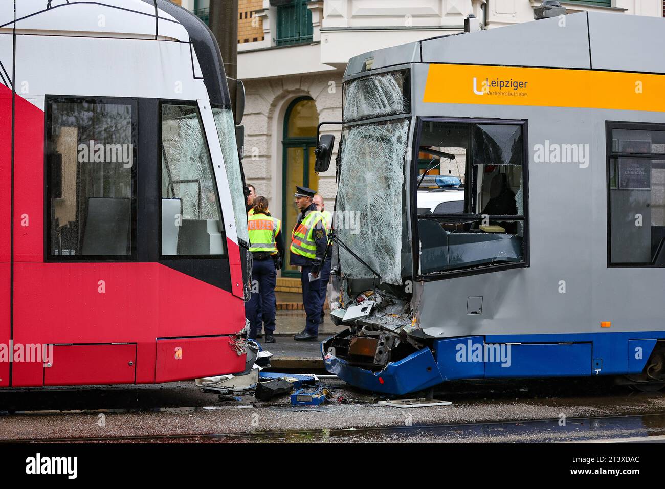 Lipsia, Germania. 27 ottobre 2023. Agenti di polizia in piedi accanto a due tram coinvolti nell'incidente. Diverse persone sono rimaste ferite in una collisione posteriore di due tram qui la stessa mattina. Uno dei conducenti è rimasto intrappolato nell'incidente. E' rimasto ferito, così come diversi passeggeri sui tram. Crediti: Jan Woitas/dpa/Alamy Live News Foto Stock