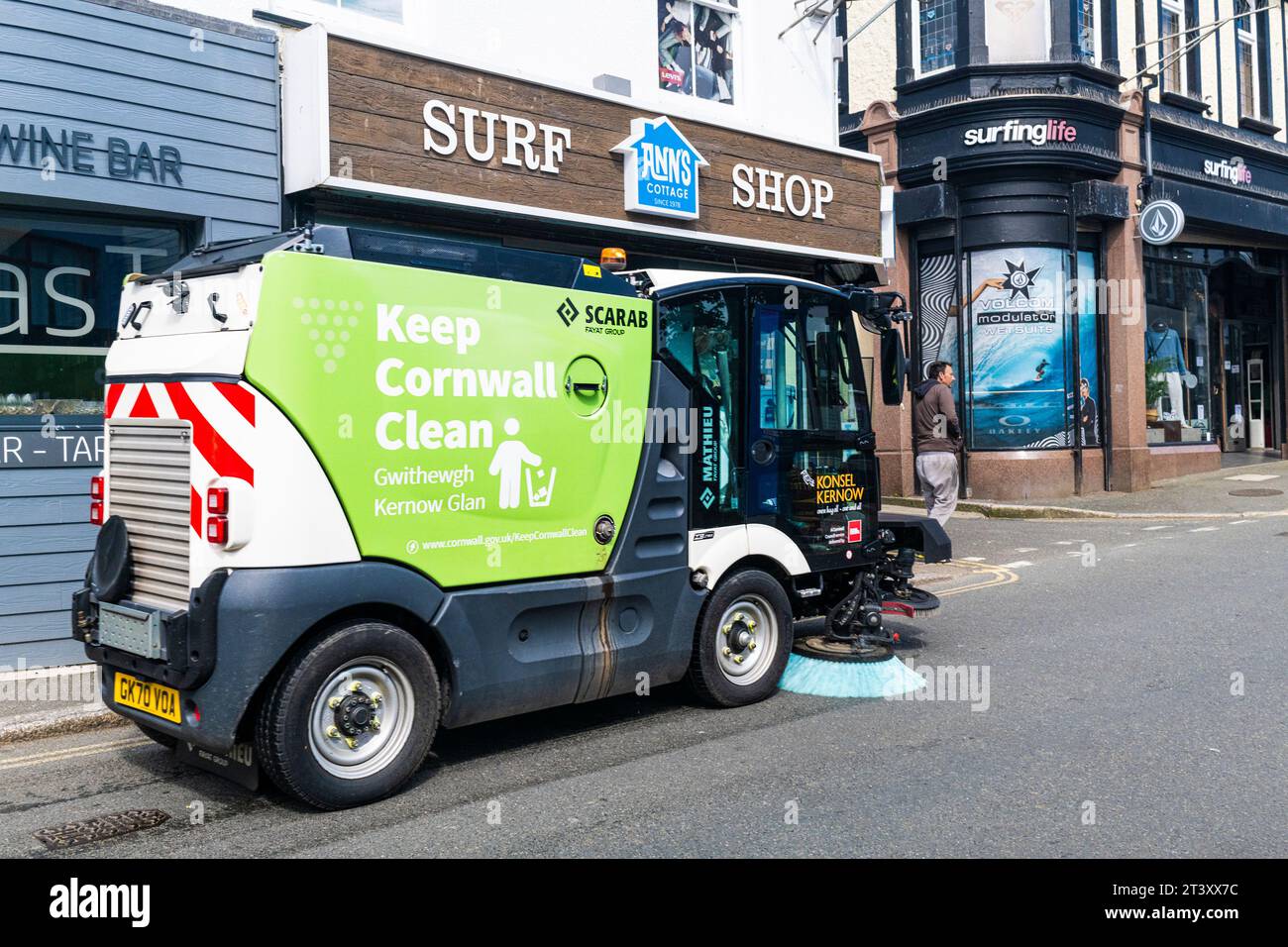 Una macchina per la pulizia stradale Scarab viene guidata lungo una strada nel centro di Newquay, in Cornovaglia, nel Regno Unito. Foto Stock