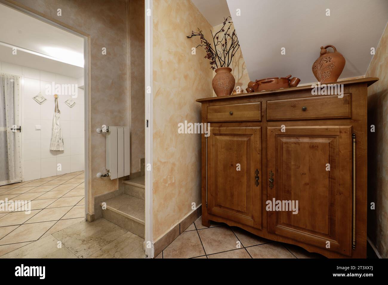 Credenza in legno verniciato scuro accanto a una scala Foto Stock