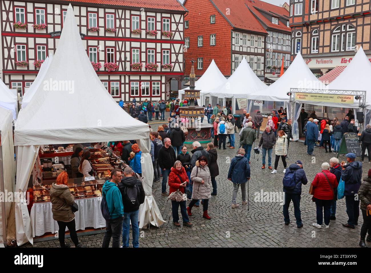 Wernigerode, Germania. 27 ottobre 2023. I banchi di vendita dei commercianti si trovano sulla piazza del mercato di Wernigerode. Per dare il via al festival del cioccolato "chocolART", una selezione di artisti e cioccolatieri, pasticceri e produttori di cioccolato si presentano a Wernigerode, sulla piazza del mercato. Il chocoPFAD collega anche le offerte di cioccolato in ristoranti, negozi e caffetterie fuori dagli eventi del mercato. Crediti: Matthias Bein/dpa/Alamy Live News Foto Stock