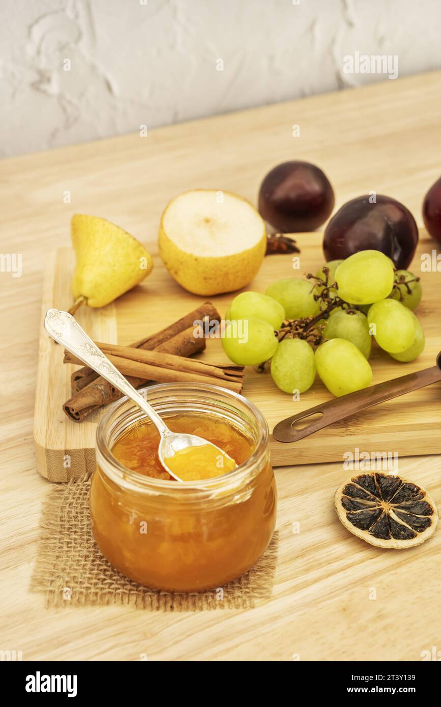 Natura morta con frutta fresca e fette di agrumi secche, marmellata di pesca e condimenti dolci Foto Stock