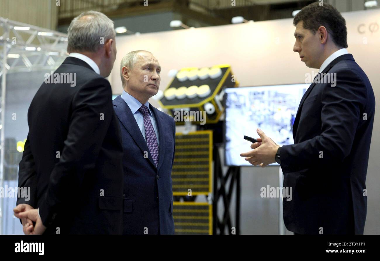 Korolyov, Russia. 27 ottobre 2023. Il capo di Roscosmos Yuri Borisov, a sinistra, e il presidente russo Vladimir Putin, al centro, ascoltano un ingegnere durante un tour della Rocket and Space Corporation, il 27 ottobre 2023 a Korolyov, Oblast' di Mosca, Russia. Crediti: Gavriil Grigorov/Cremlino Pool/Alamy Live News Foto Stock