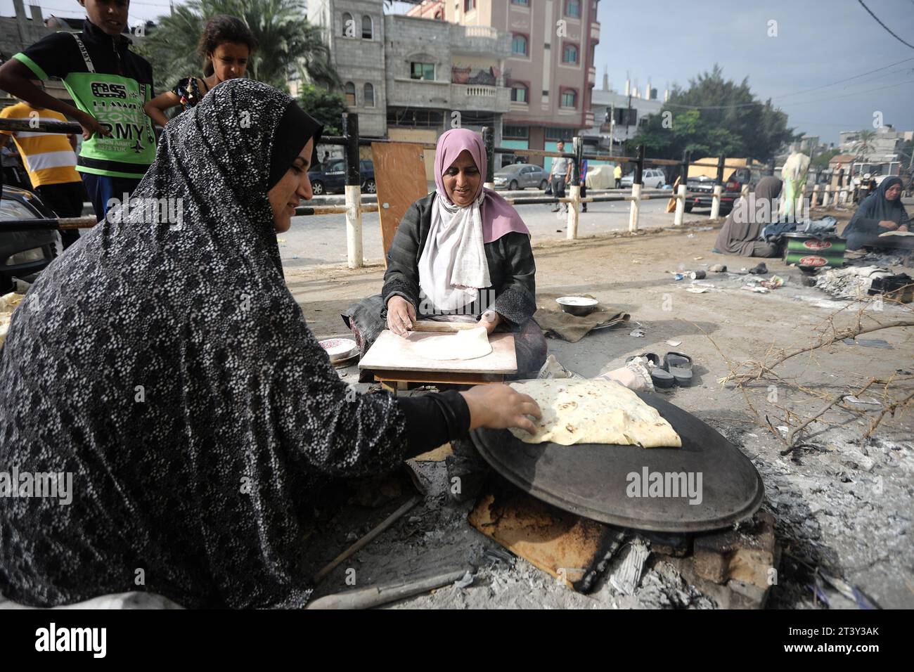 Rafah, Gaza. 26 ottobre 2023. Le donne palestinesi preparano il tradizionale pane azzimo su un fuoco aperto in un rifugio per famiglie sfollate principalmente dal nord della Striscia di Gaza, in una scuola gestita dalle Nazioni Unite a Rafah, nella Striscia di Gaza meridionale venerdì 27 ottobre 2023. Lo sciopero israeliano continua a Gaza in mezzo alla carenza di forniture mediche, acqua, gas, carburante e spegnimento. Foto di Ismael Mohamad/UPI. Crediti: UPI/Alamy Live News Foto Stock