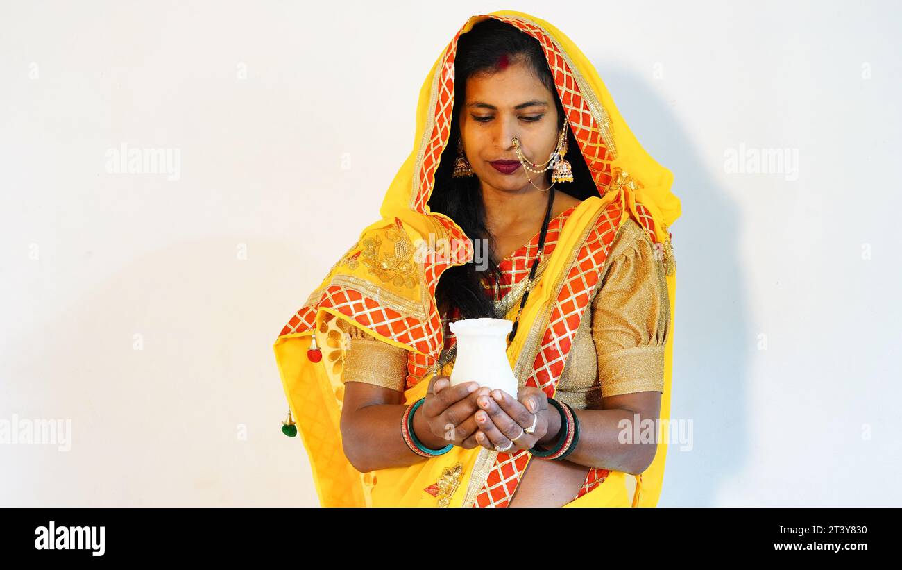 Giovane donna indiana che indossa costume tradizionale e tiene karwa o karva al festival di karva chauth. Foto Stock