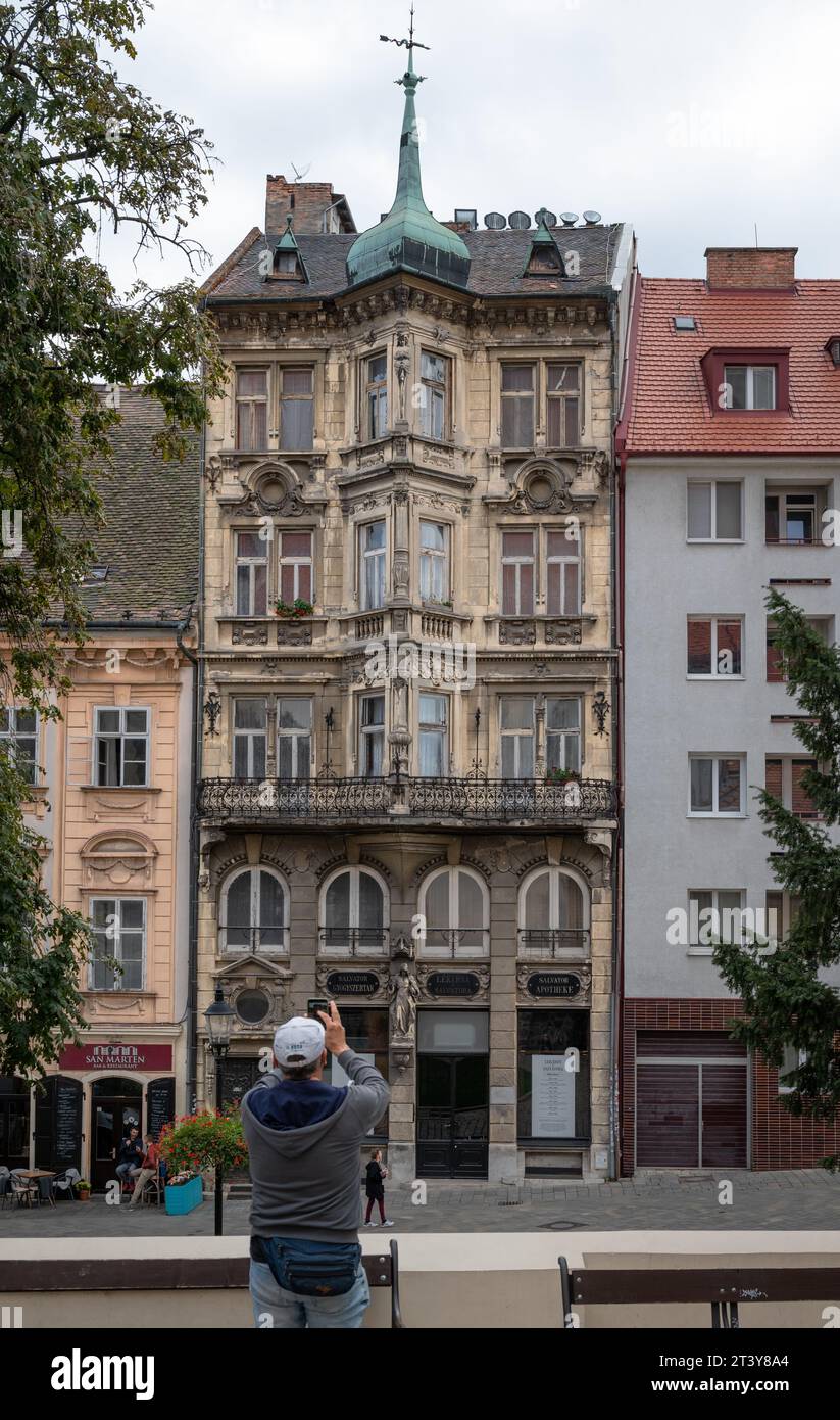 Un turista che fa una foto di un edificio di neorensance a Bratislava Foto Stock