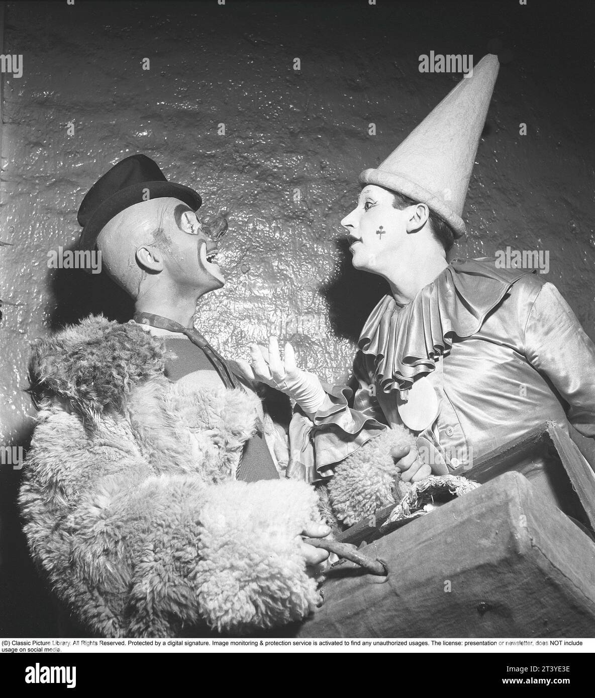 Clown da circo negli anni '1940 Due clown in diversi costumi di scena sono in piedi l'uno di fronte all'altro discutendo e parlando tra loro. Fanno parte del Brazil Jack Circus. Svezia 1943. Kristoffersson rif F6-2 Foto Stock