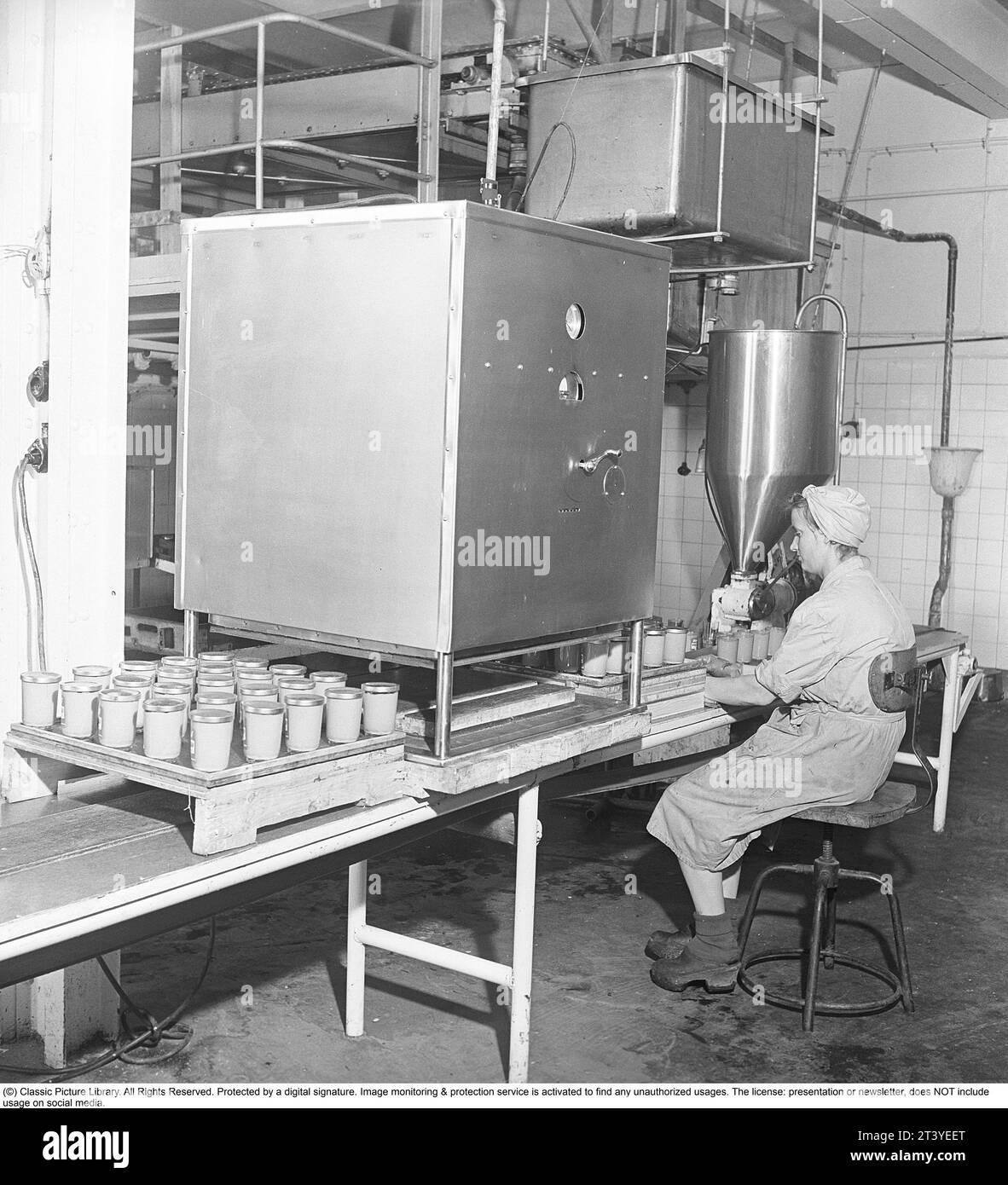 Lavori negli anni '1940 Interni delle fabbriche dell'azienda alimentare Winborg, dove una dipendente donna siede nella linea di produzione di cibo in vasetti di vetro. Svezia 1949. Kristoffersson rif. AM1-4 Foto Stock