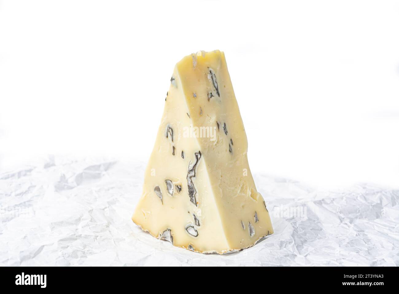 pezzo triangolare di formaggio con muffa su carta bianca a forma di primo piano Foto Stock