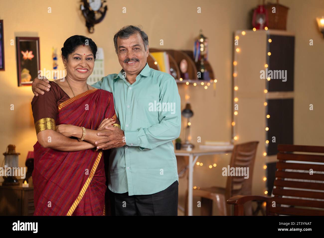 Coppie anziane indiane sorridenti e sorridenti che guardano la macchina fotografica a casa al festival diwali - concetto di legame familiare, compagnia e.. Foto Stock