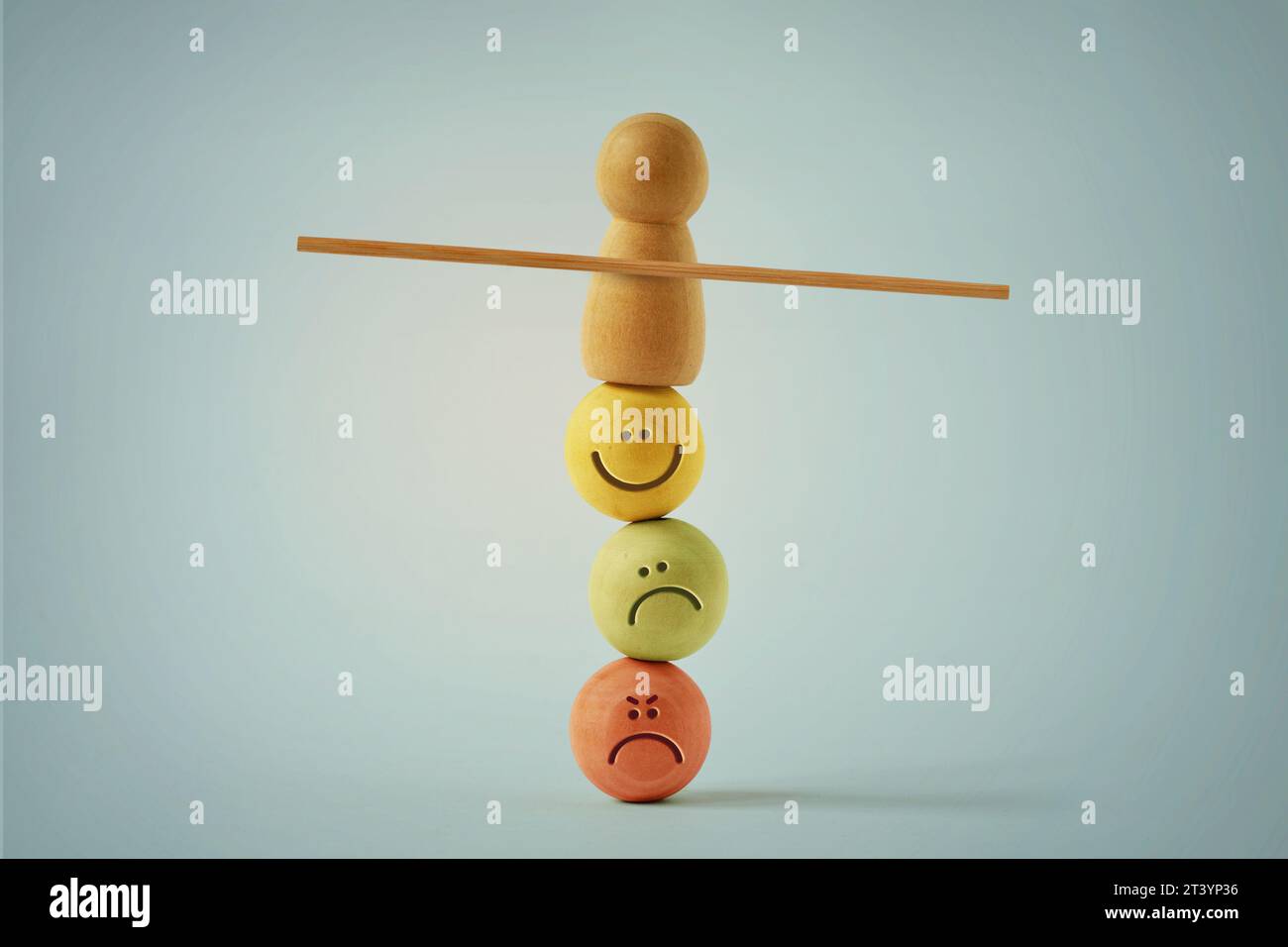 Pedone di legno che si bilancia su perline con diverse espressioni d'umore - concetto di equilibrio emotivo e mentale Foto Stock