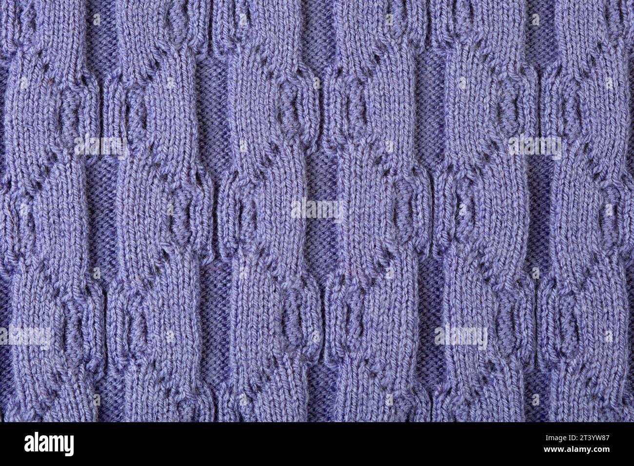 Sfondo astratto lilla lavorato a maglia. Tessuto a maglia grande con motivo. Primo piano di una coperta a maglia. Copia spazio Foto Stock