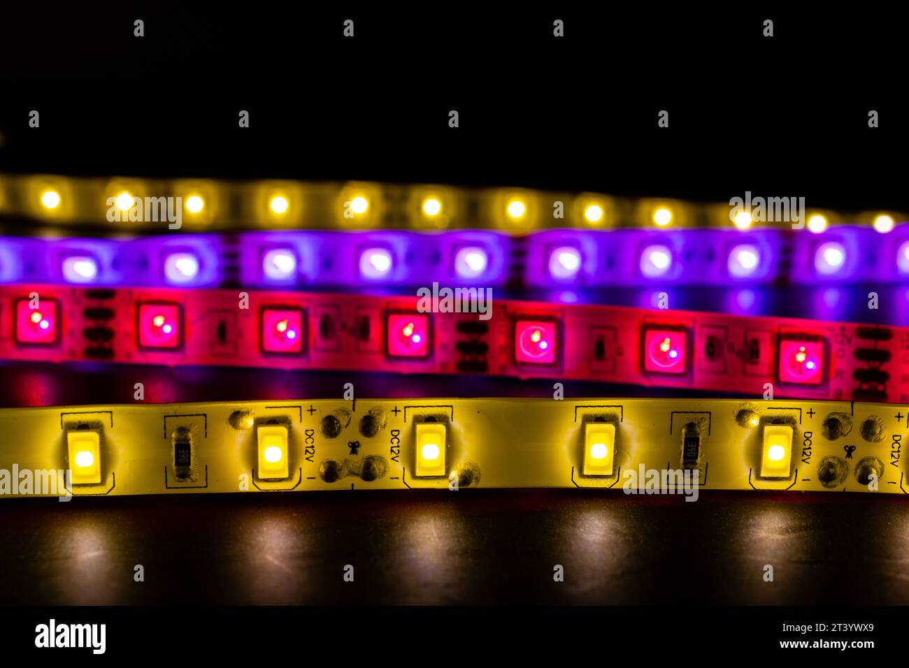 Una pila di luci a LED su strisce di illuminazione flessibili a spirale, di vari colori Foto Stock