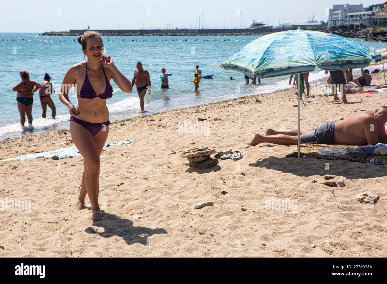 La giovane ragazza Ucraina cammina sulla spiaggia di sabbia Miguel a Odessa, Ucraina, godendo di una vacanza molto conveniente, confortevole e rilassante, agosto 2017 Foto Stock