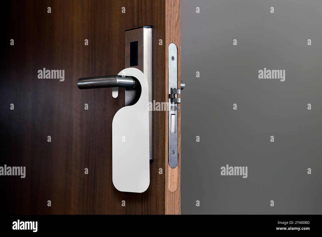 Porta in legno con etichetta vuota appesa alla maniglia. Modello ideale per il mockup non disturbare. Foto Stock