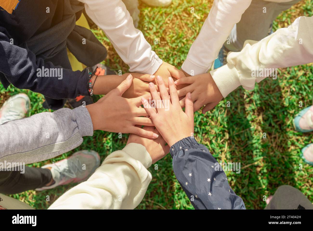 Un gruppo di mani di bambini unite al centro. Cooperazione e cameratismo tra amici. L'unità e la collaborazione rafforzano il team. Insieme per un Foto Stock