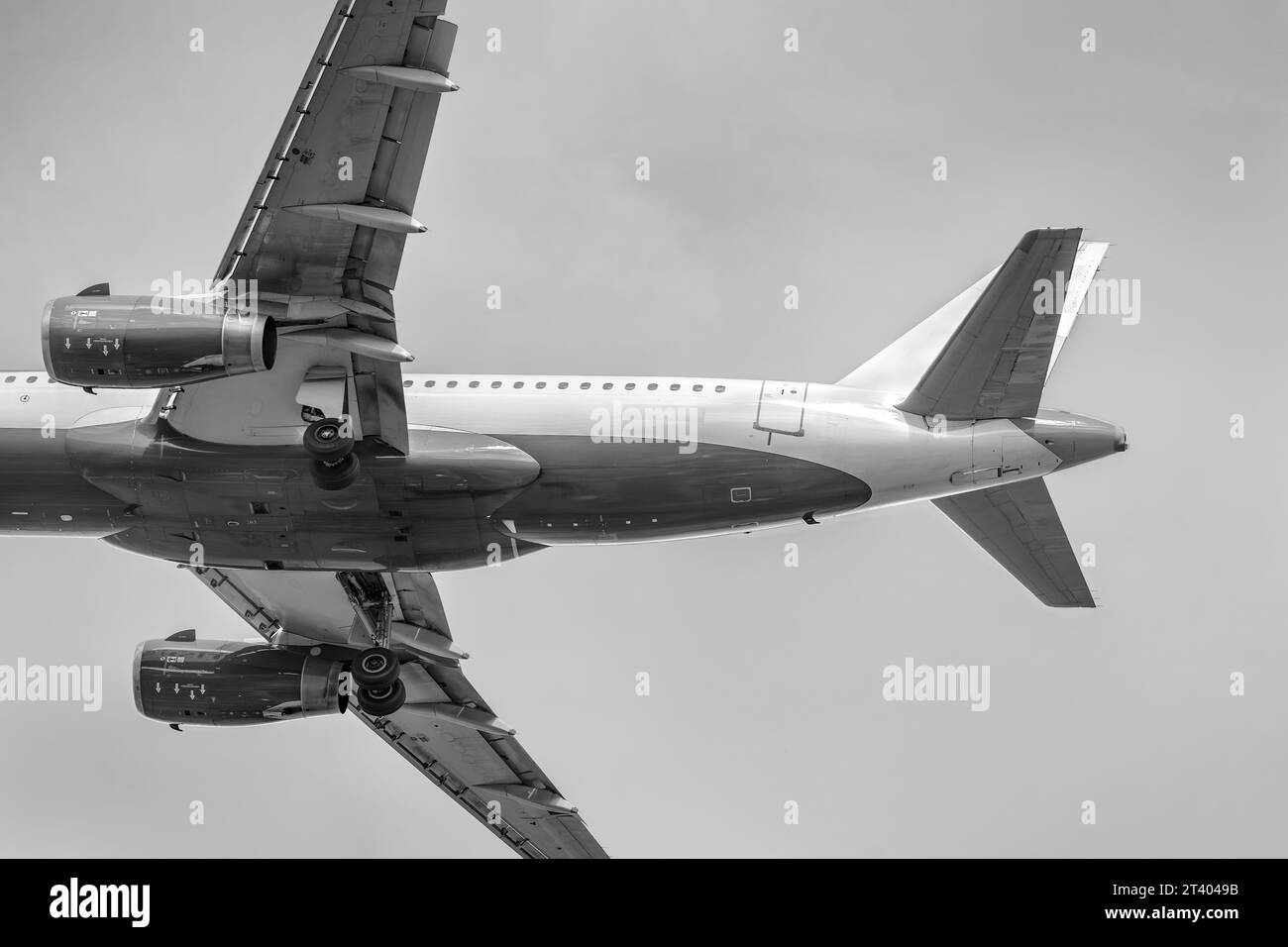 Aereo passeggeri che si prepara ad atterrare, vista dal basso. Volo aereo. Aereo Airbus. Foto in bianco e nero. Foto Stock