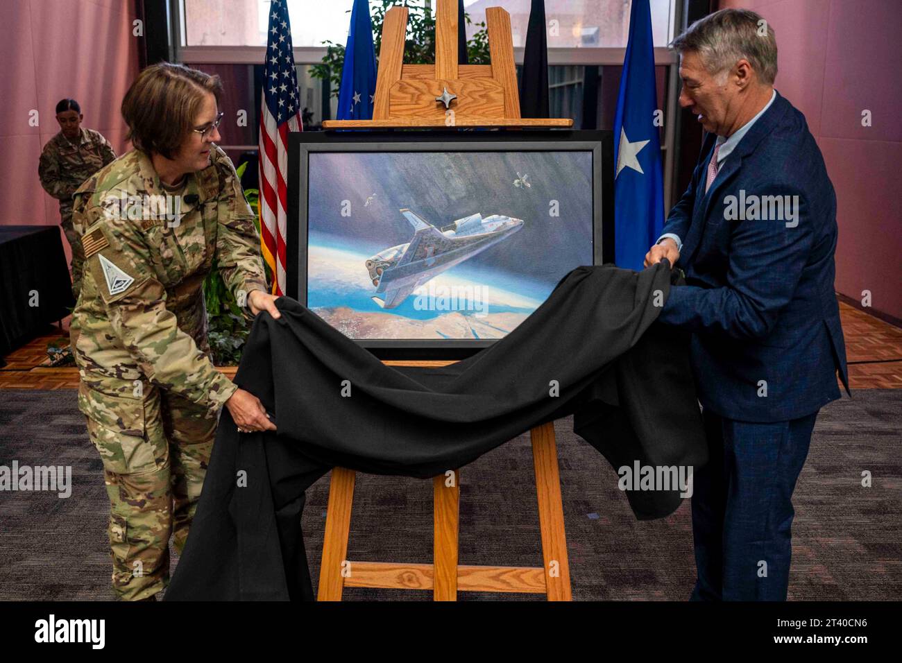 20 ottobre 2023 - Peterson Space Force base, Colorado, USA - U.S. Air Force Brig. Joy Merritt, Individual Mobilization Augmentee to the Space Operations Command Commander e Rick Herter, artista commissionato, rivela Painting, High Ground Intercept durante una cerimonia al quartier generale dello Space Operations Command presso Peterson Space Force base, Colorado, 20 ottobre 2023. L'opera d'arte è la prima per il comando e raffigura un futuristico veicolo spaziale statunitense che intercetta un satellite avversario, che a sua volta si posiziona per disabilitare un satellite amichevole. (Immagine di credito: © U.S. Space Force/ZUMA Press Wire) Foto Stock