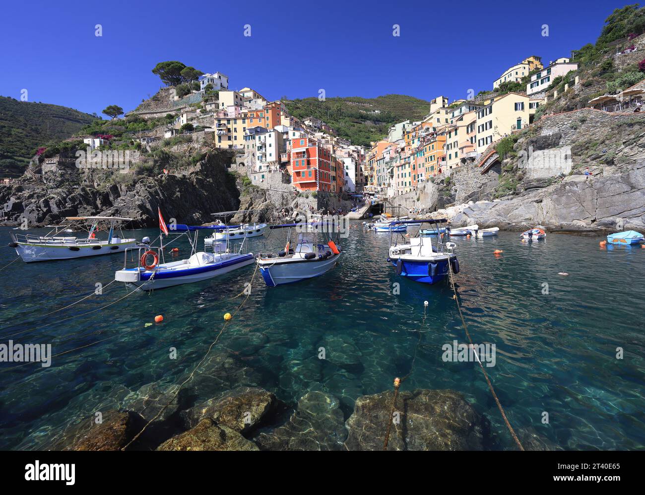 Skyline del villaggio di Riomaggiore con il Mar Ligure e barche in primo piano, Italia Foto Stock