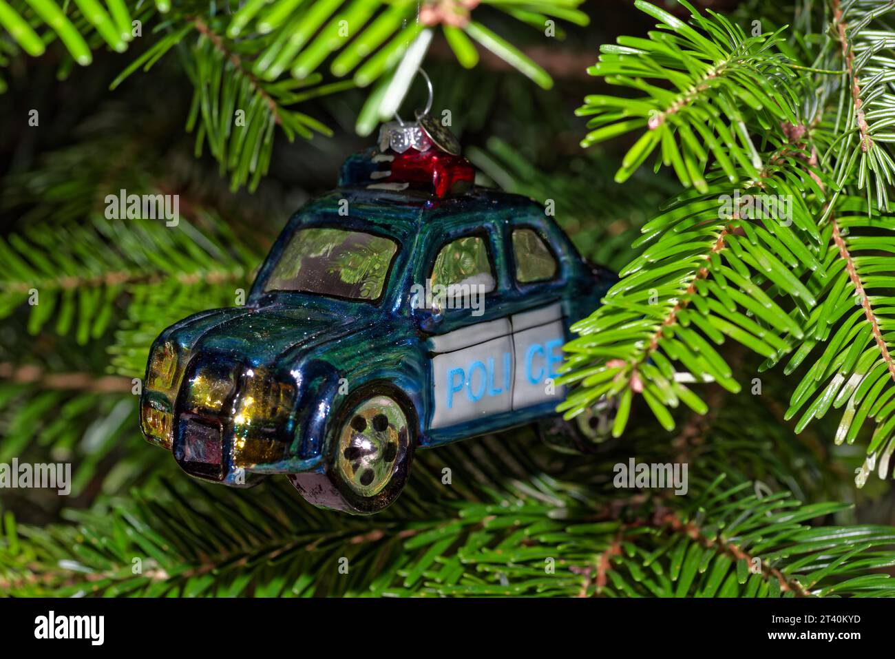 Primo piano dell'auto della polizia blu appesa all'albero di Cristmas e ai rami verdi Foto Stock