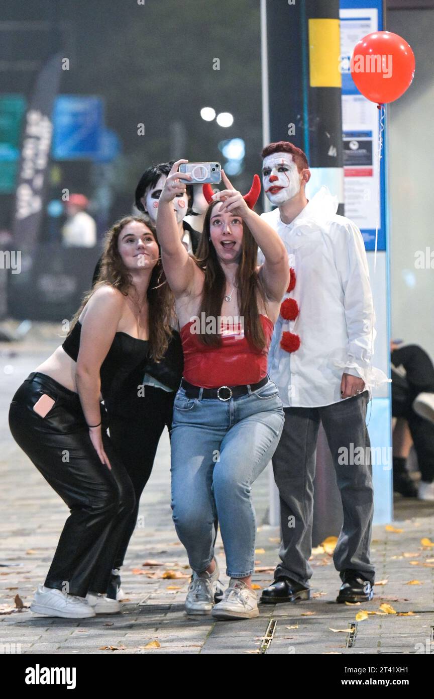 Broad Street, Birmingham, 28 ottobre 2023 - migliaia di festaioli sono andati a Broad Street a Birmingham venerdì sera e sabato mattina. I clubber si vestono da diavoli, agenti di polizia cattivi e altri abiti inquietanti mentre si fanno strada lungo la famigerata striscia dei nightclub. Molti festaioli sembravano un po' peggio per l'abbigliamento, potendo riposarsi su marciapiedi e gradini dopo una lunga serata con gli amici, alcuni si sono divertiti un meritato servizio da asporto prima di prendere un taxi per tornare a casa. La maggior parte era comunque in spiriti gioiosi, nonostante le temperature calassero in figure singole con alcuni abiti molto rivelatori. Altro Foto Stock