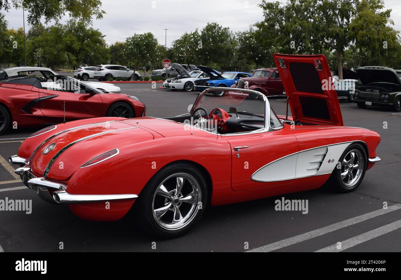 Corvette rossa classica convertibile in una mostra di auto d'epoca nel parcheggio esterno con il cofano anteriore sollevato Foto Stock