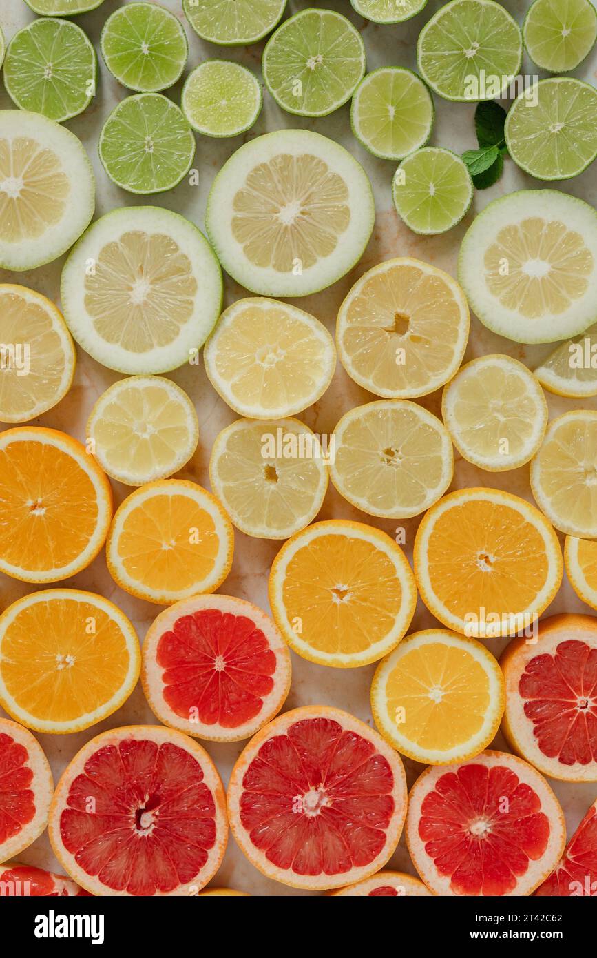 Una vivace esposizione di agrumi, composta da limoni e limoni in vari tipi su un tavolo di legno Foto Stock
