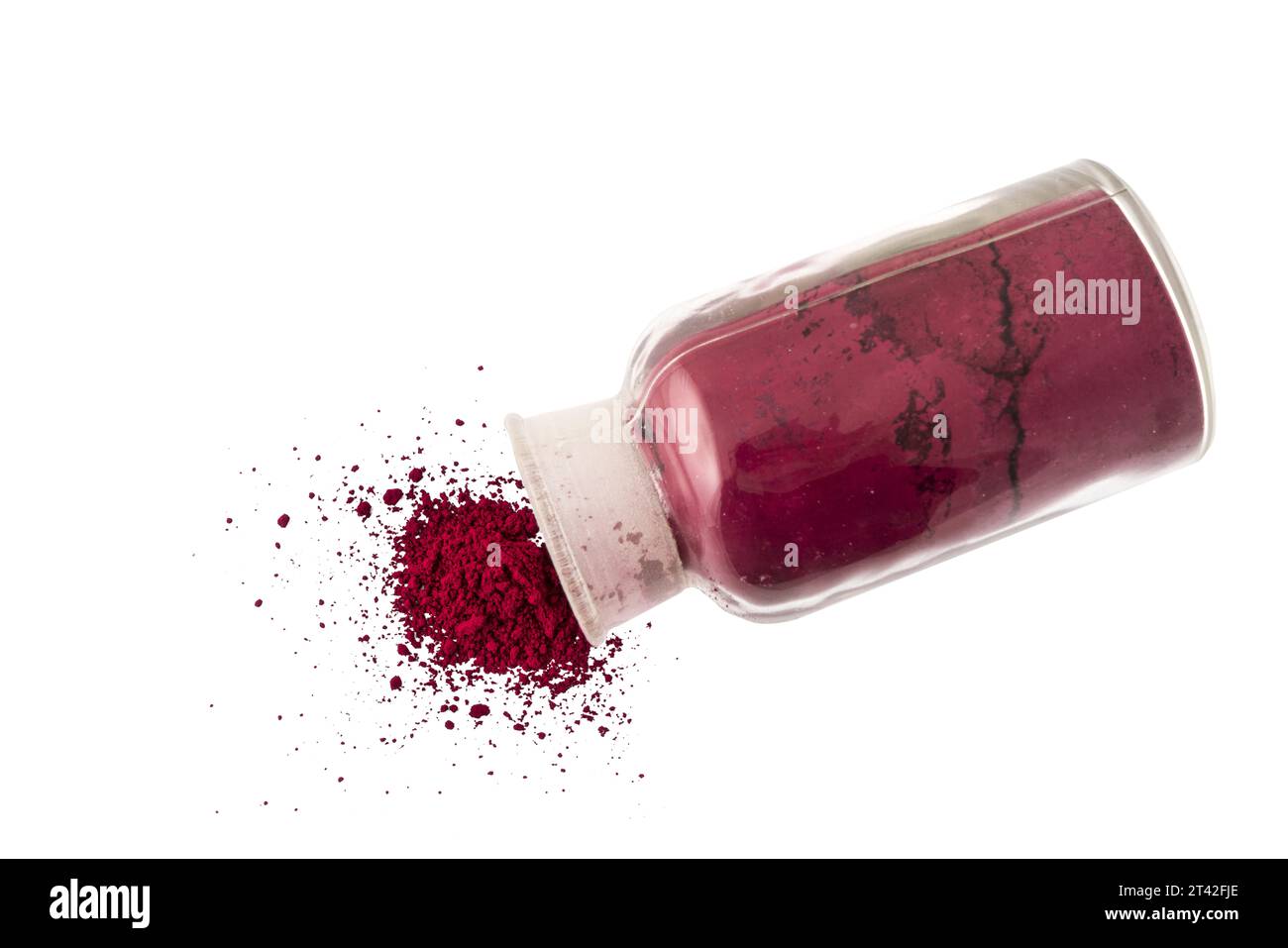 Polvere di colorante rosso che fuoriesce da un flacone di vetro su una superficie trasparente Foto Stock