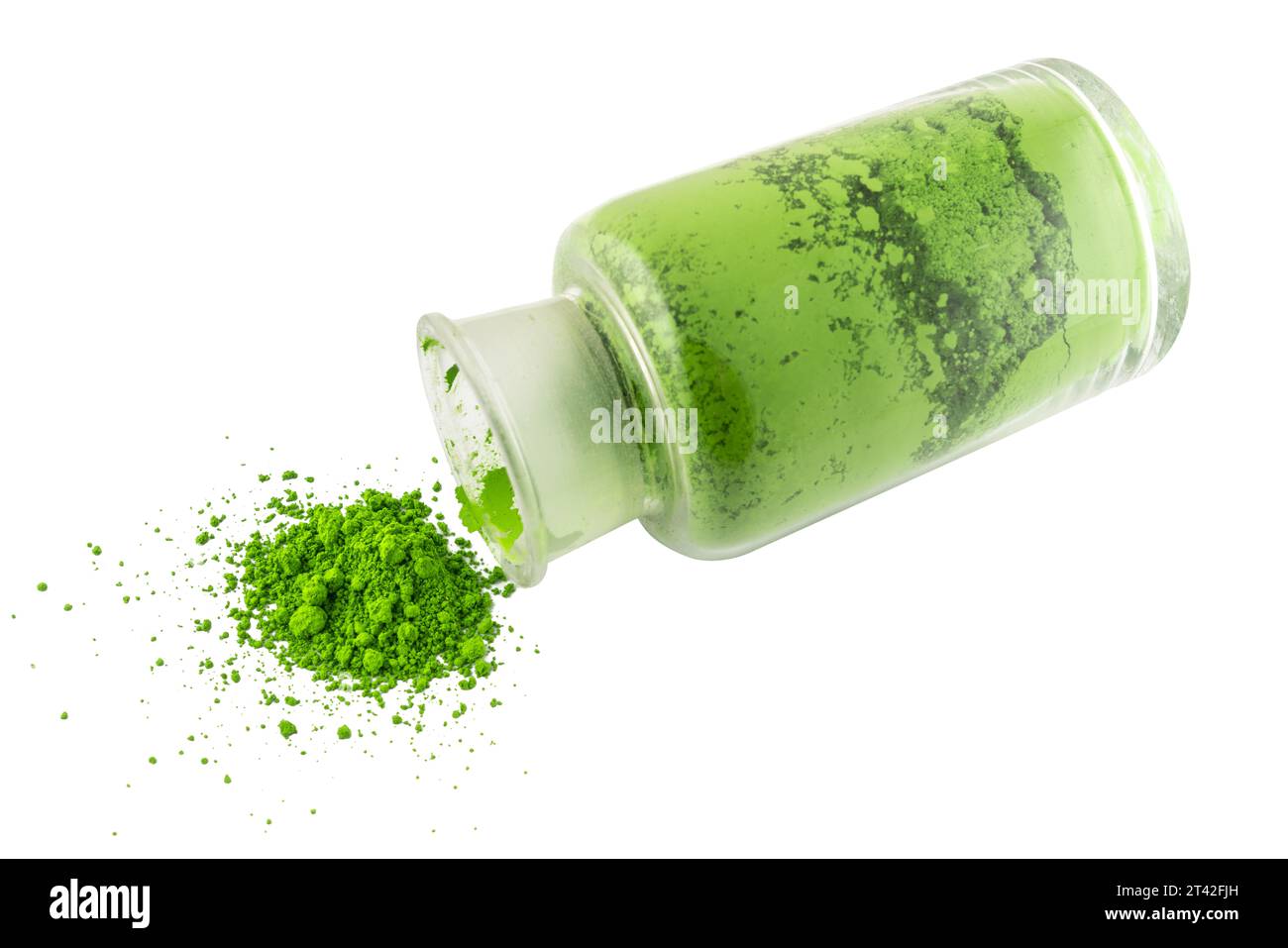 polvere di colorante verde che fuoriesce da un flacone di vetro su una superficie trasparente Foto Stock