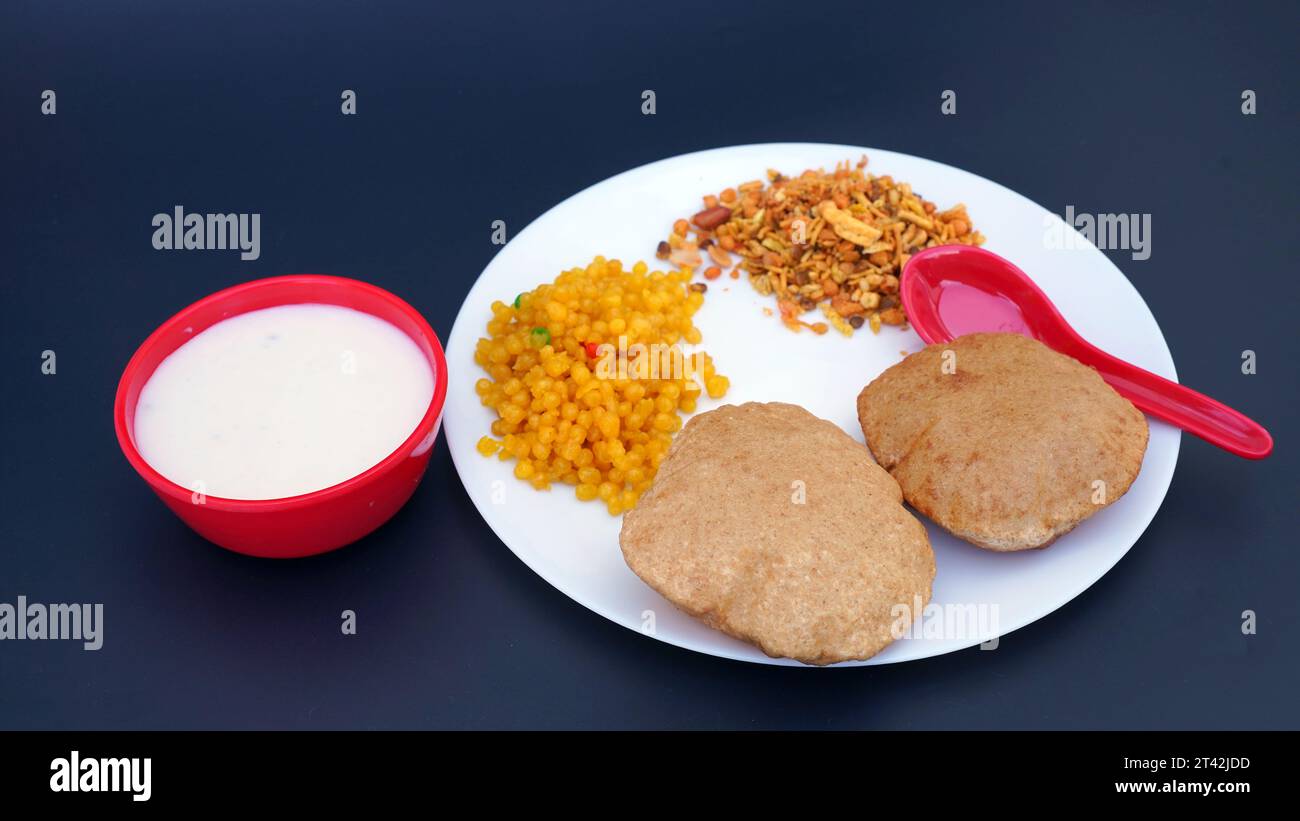 Cibo indiano - puri Bhaji e kheer. Ricetta piccante di patate semi secche dell'India settentrionale nota anche come Batata o Aloo ki Sabji, curry di patate o dum alu curry Foto Stock