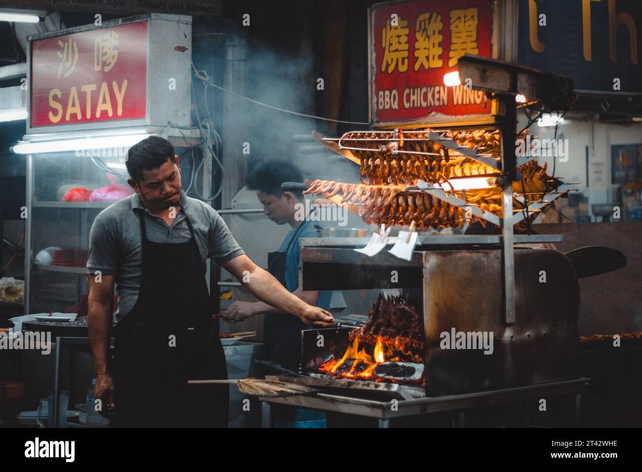 Un uomo cucina a Jalan Alor a Kuala Lumpur, Malesia Foto Stock