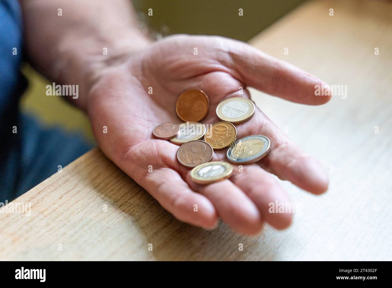 Augusta, Baviera, Germania. 27 ottobre 2023. Un vecchio ha poche monete in euro in mano. Pensionato con concetto di poco denaro *** Ein Alter Mann hält wenige Euro Geldmünzen in der Hand. Rentner mit wenig Geld Konzept Credit: Imago/Alamy Live News Foto Stock