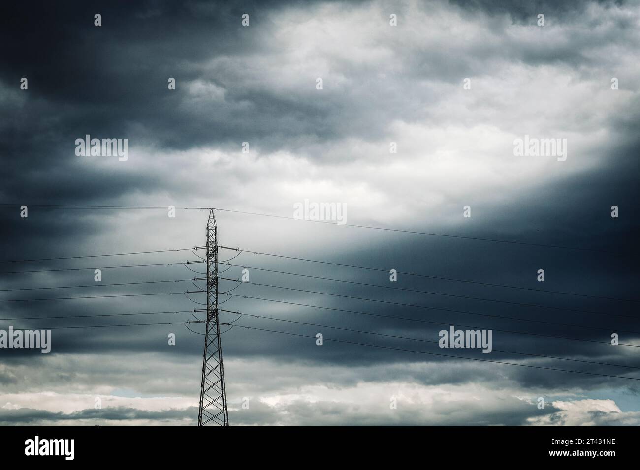 Linee elettriche ad alta tensione contro un cielo grigio drammatico, Spagna Foto Stock