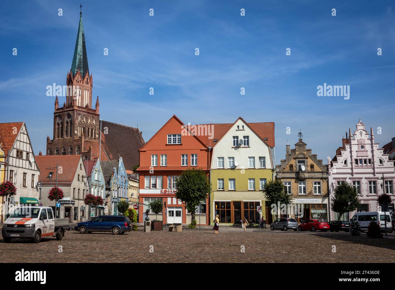 Trzebiatow, Polonia - 18 settembre 2023: Chiesa medievale di Mariacki e case colorate nella piazza del mercato del centro storico della città. Foto Stock