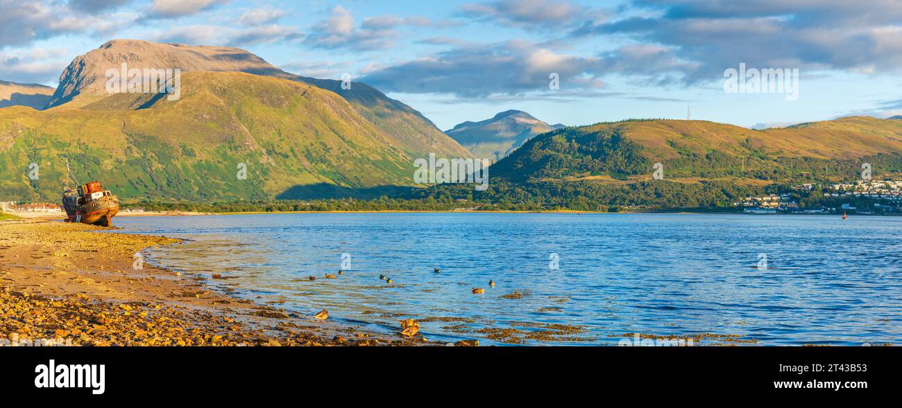 Il naufragio della Old Boat of Caol si trova sulla spiaggia rocciosa di Corpach of Loch EIL con Ben Nevis sullo sfondo, Fort William, Highland, Scozia, ONU Foto Stock