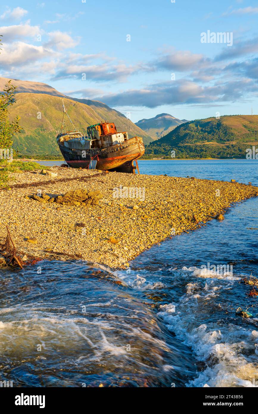 Il naufragio della Old Boat of Caol si trova sulla spiaggia rocciosa di Corpach of Loch EIL con Ben Nevis sullo sfondo, Fort William, Highland, Scozia, ONU Foto Stock