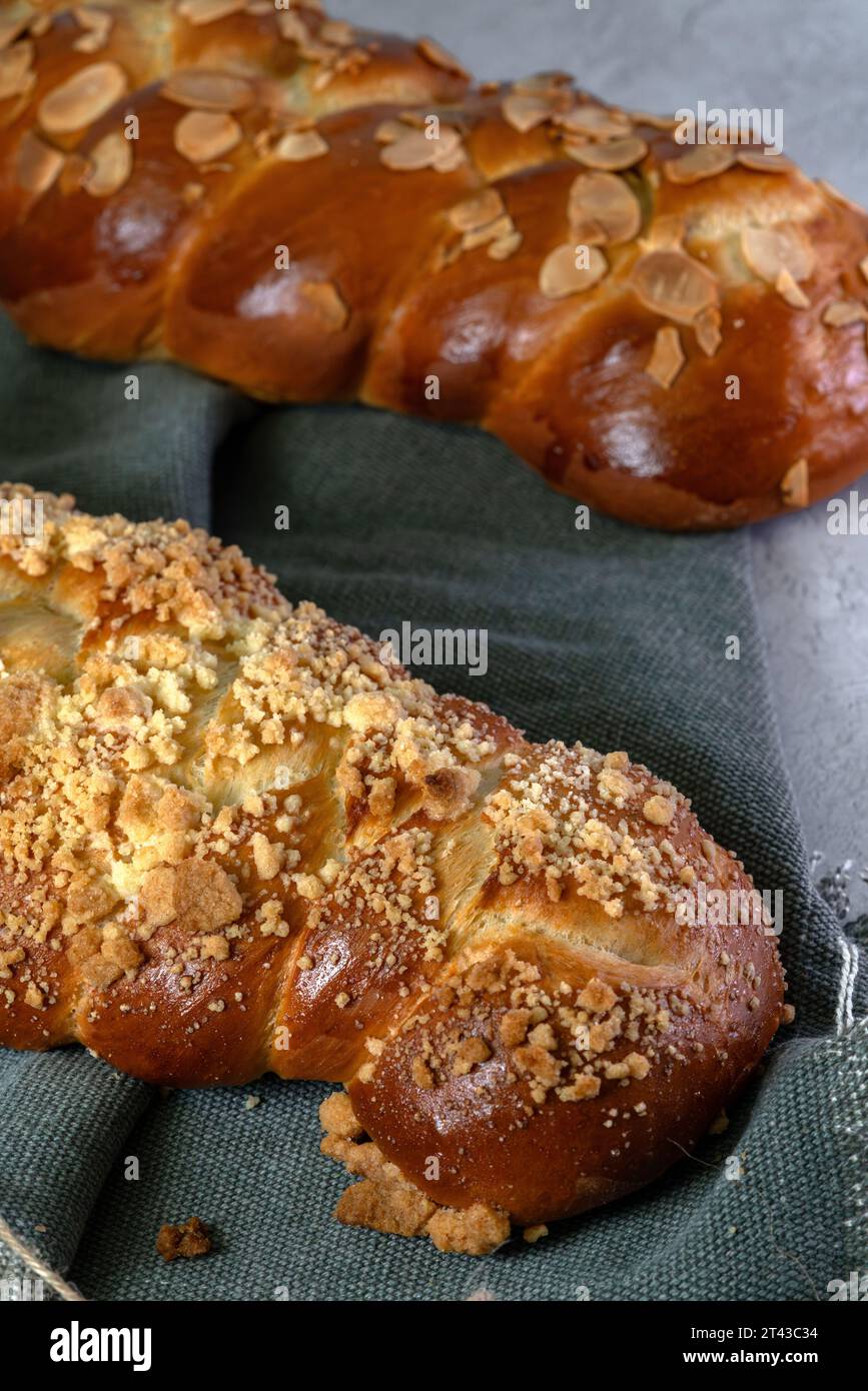Due tipi di pane Challah con mandorle e crogioli dolci in un macro shot verticale. Foto Stock