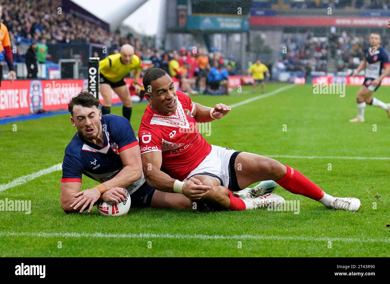 L'inglese Matty Ashton (a sinistra) segna la seconda meta della partita in quanto Will Hopoate (a destra) di Tonga non è in grado di impedirgli di segnare durante l'International test Series match al John Smith's Stadium di Huddersfield. Data immagine: Sabato 28 ottobre 2023. Foto Stock