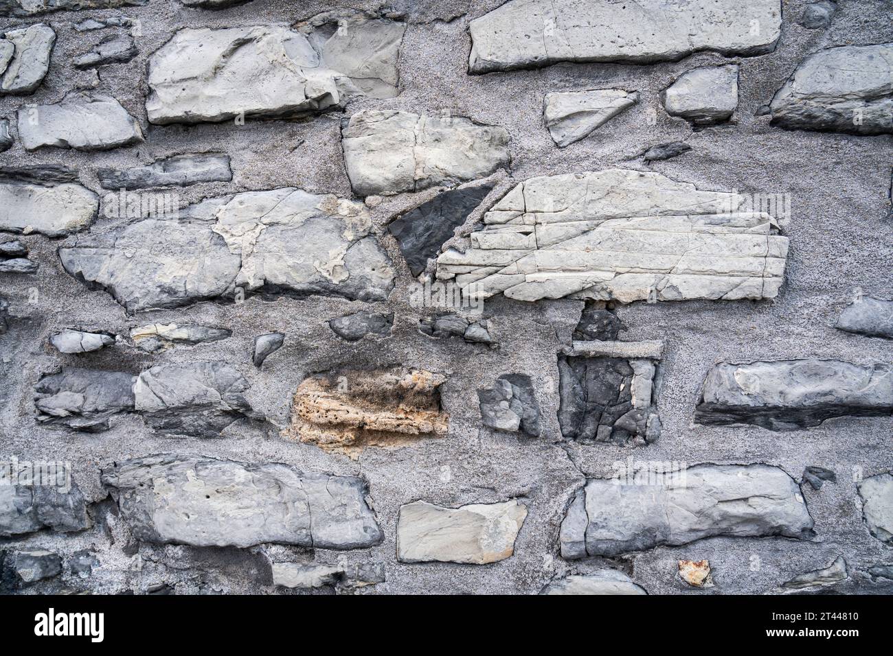 Primo piano del muro in pietra ruvida su un edificio molto vecchio Foto Stock