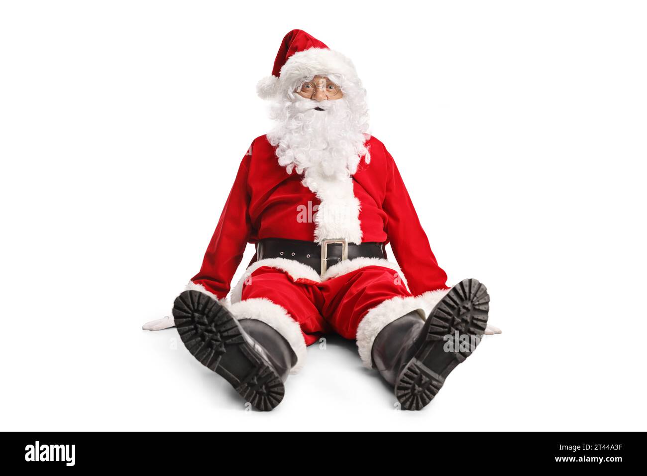 Divertente Babbo Natale seduto a terra e guardando la fotocamera isolata su sfondo bianco Foto Stock