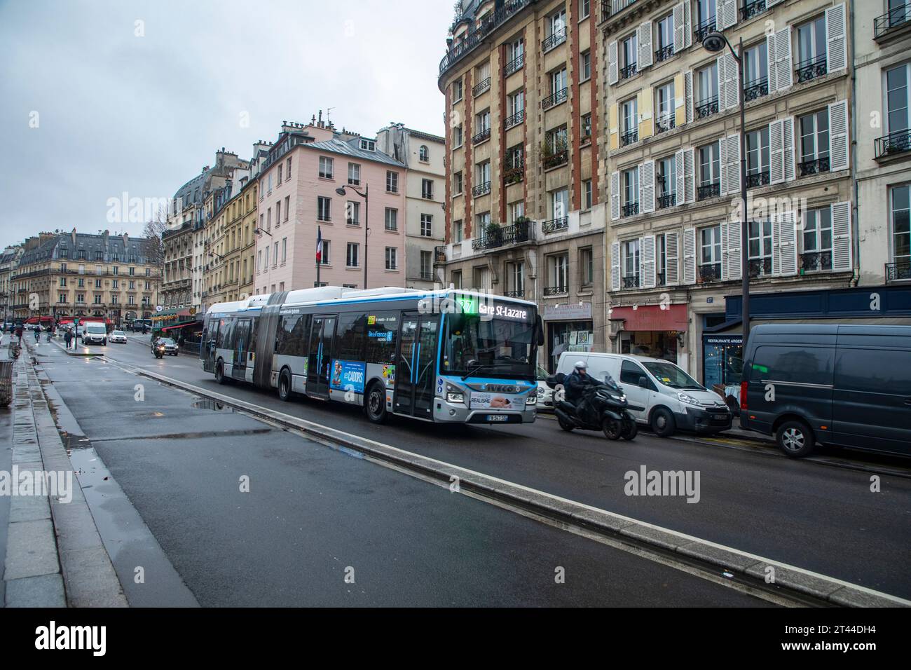 Un autobus cittadino articolato percorre le strade di Parigi, in Francia, come parte del sistema di transito urbano. Foto Stock