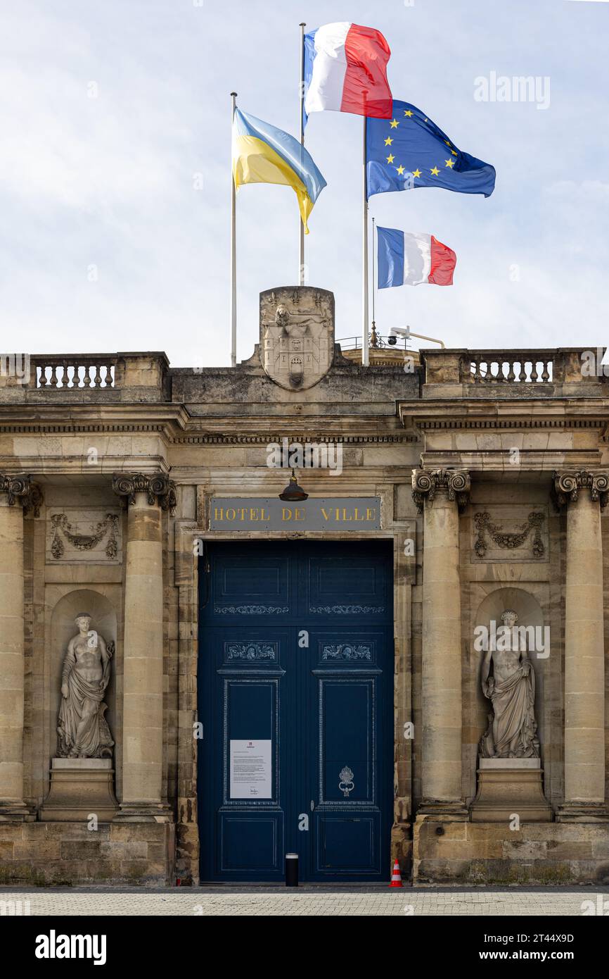 Ingresso principale del Palais Rohan, che mostra la porta d'ingresso, i satues e le bandiere galleggianti di Bordeaux, Francia Foto Stock
