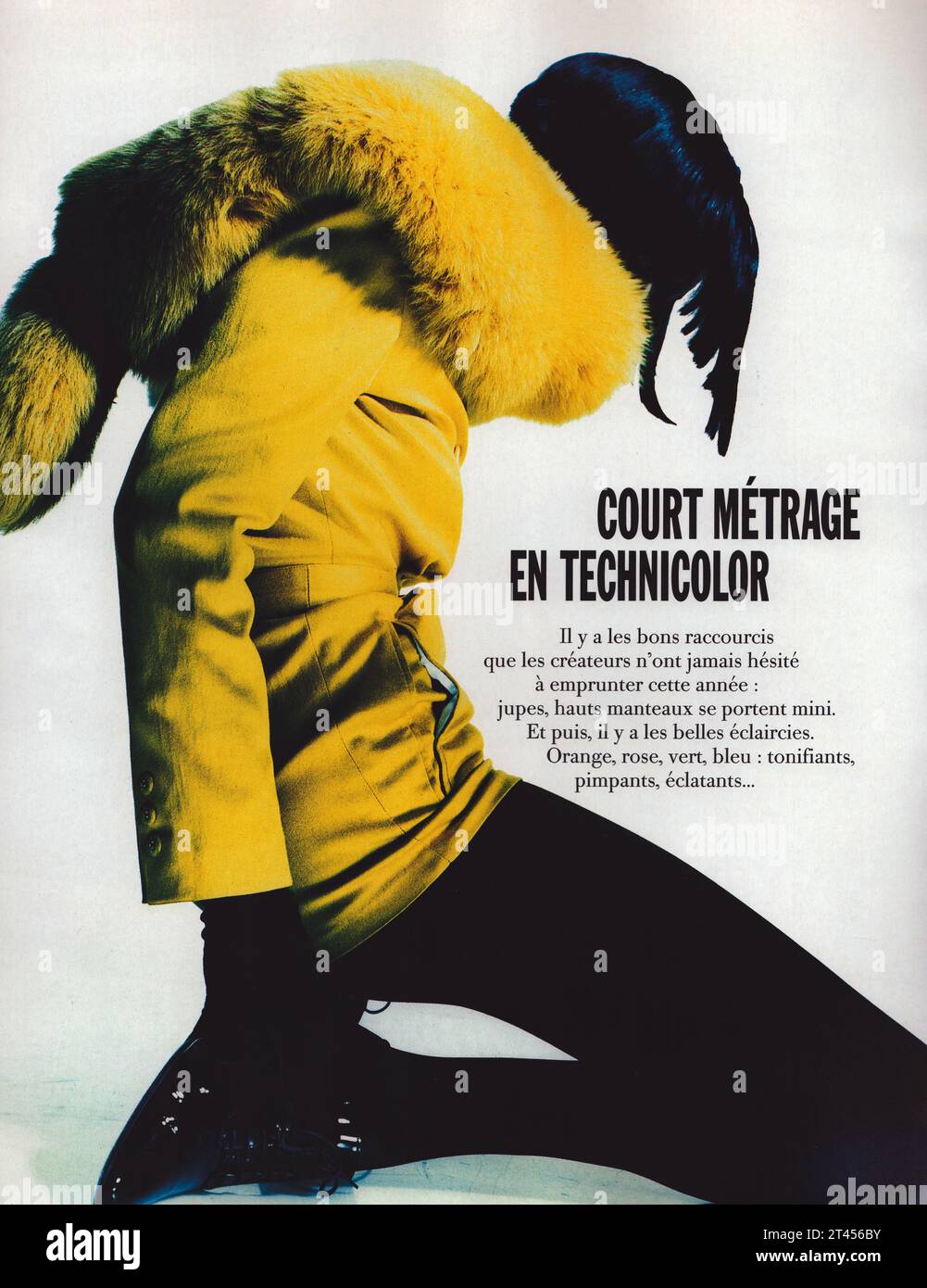 Fotografia vintage alla moda, donna seduta sul pavimento con giacca gialla di Michael Klein e maglione giallo e calze Wolford nere Foto Stock